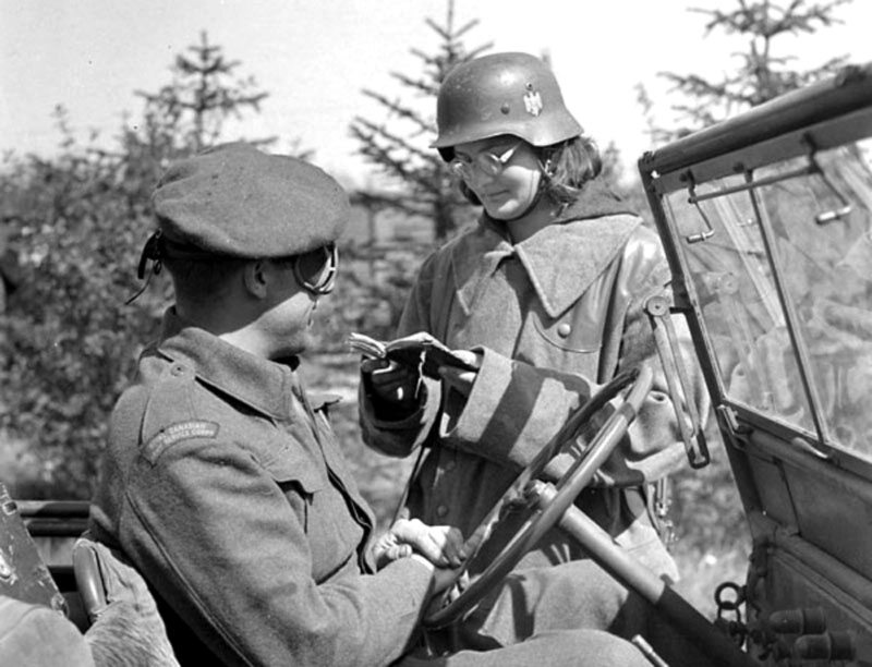 Polka w mundurze niemieckim sprawdza dokumenty przy głównej bramie obozu w Haren po jego wyzwoleniu, 7 maja 1945 r.